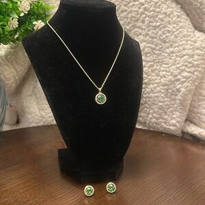 Gold-tone necklace and earrings set. Green center with clear rhinestones around.